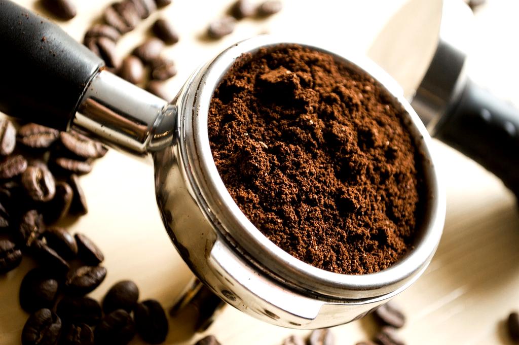 Espresso machine portafilter with fresh shot brewed into ceramic cup